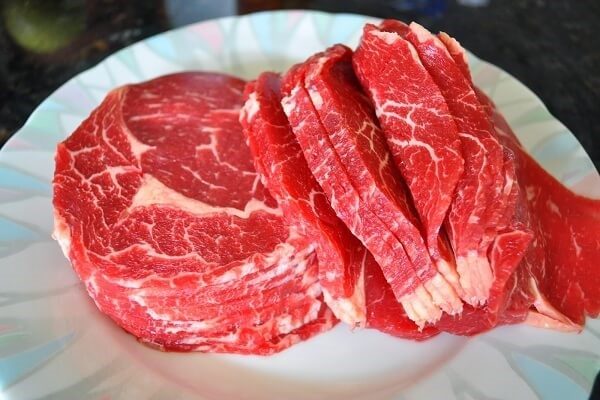Thịt bò thái mỏng và cho vào tô, ướp thịt để trong 10 – 15 phút 