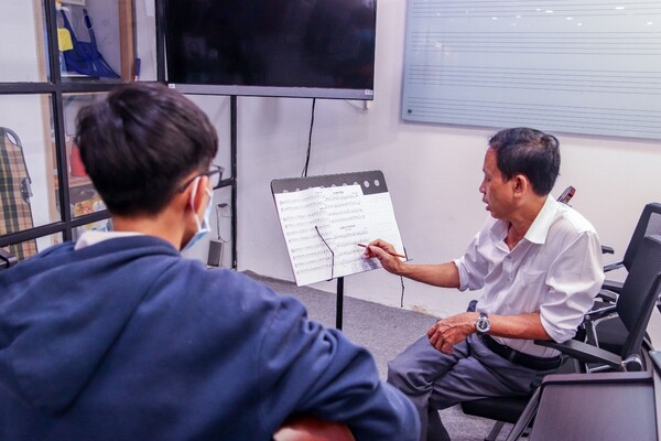 giảng viên giúp học viên hiểu rõ bài học guitar