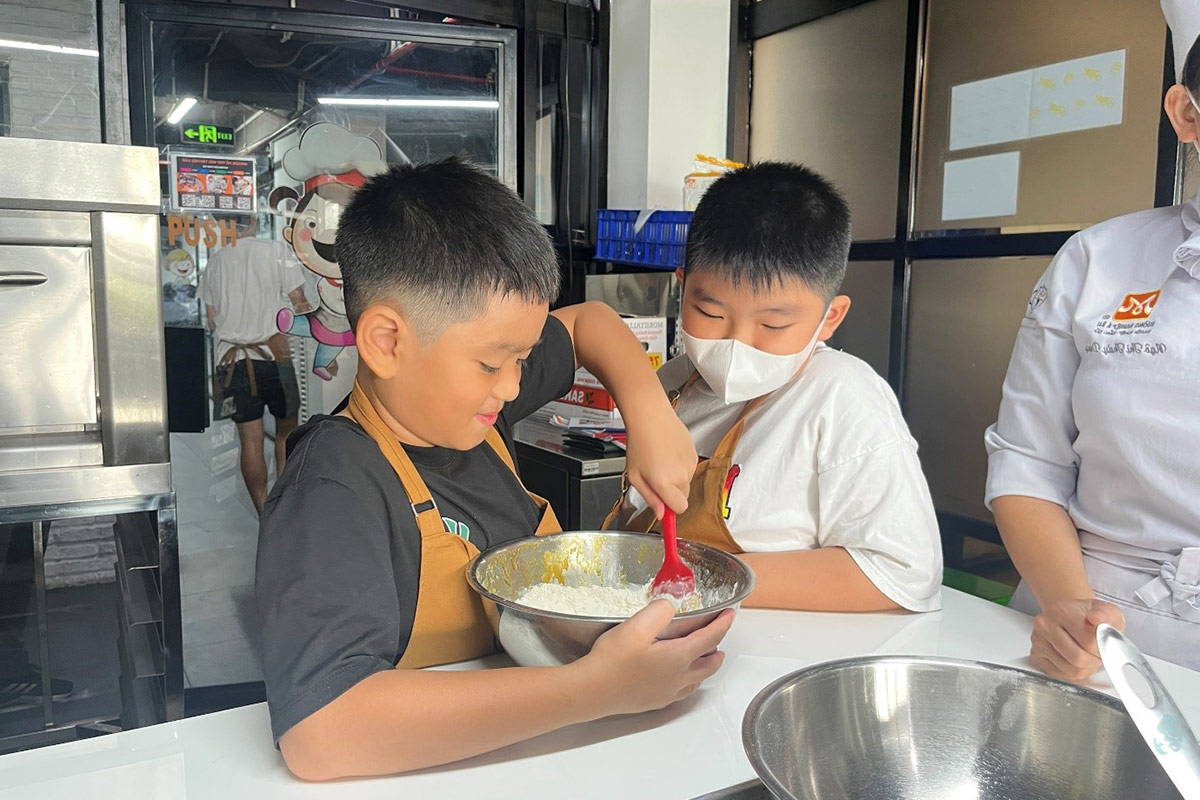 bé học trộn bột làm bánh